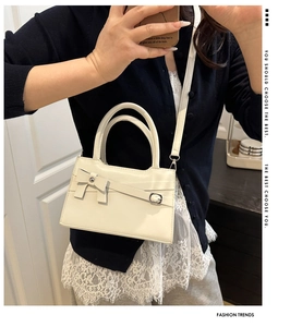 Détail du nœud papillon crème et de la texture cuir PU sur ce sac à main élégant