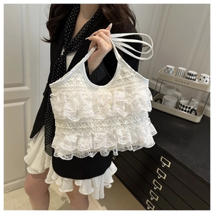 Close-up of white layered lace tote bag with elegant ruffle pleats and slim handle