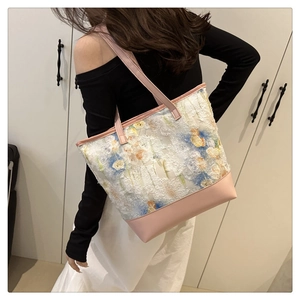 Detail of floral lace tote bag featuring pink faux leather base and straps on model