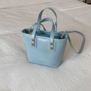 Minimalist light blue PU leather bucket bag with top handles and golden rivet accents