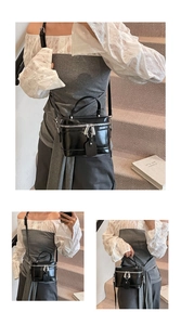 Detail of black patent leather box bag with silver zippers and adjustable strap