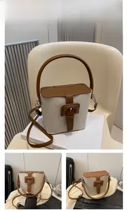 Détail du sac seau bicolore en toile beige et cuir marron avec boucle en métal robuste