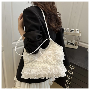 Close-up detail of tiered white lace ruffles on a sweet tote bag with leather strap