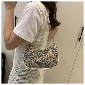 Détail du sac cabas en brocart floral avec nœud argenté et bandoulière en chaîne