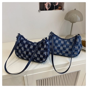 Dettaglio della borsa a mezzaluna in denim a scacchi con bordi sfrangiati e patchwork vintage