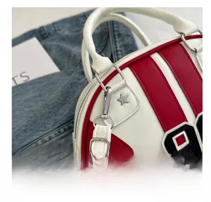 Detail van rood-wit gestreepte handtas met zilveren sternagels en nummer 9-embleem