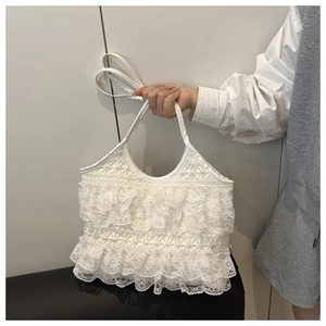 Close-up of white lace tote bag with tiered ruffles and adjustable shoulder strap