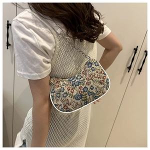 Detail of floral jacquard underarm bag with silver chain and metal bow buckle decoration