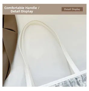 Détail du sac cabas en dentelle blanche montrant les bandoulières en similicuir lisse