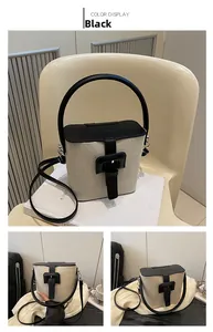 Vue détaillée du sac seau en toile beige avec rabat en cuir noir et boucle élégante