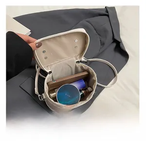 Top-down view of a round mini crossbody bag showing internal storage for cosmetics and phone