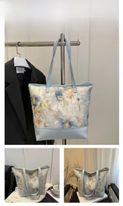 Detail of light blue floral tote bag with embroidery and premium leather handles