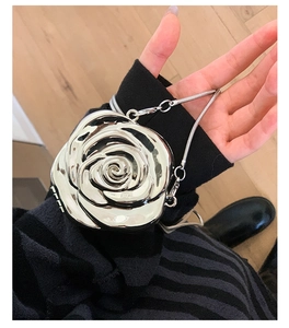 Close-up of a 3D silver rose shaped evening clutch with metallic mirror finish and chain