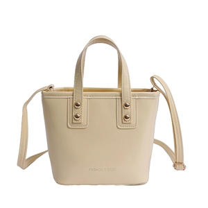 Beige luxury bucket bag with top handles and shoulder strap shown on white background