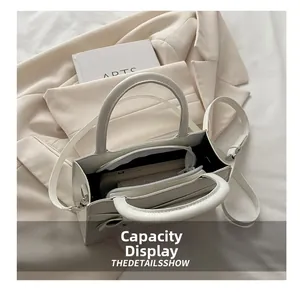 Vue intérieure du sac cabas en cuir blanc montrant sa grande capacité à trois couches