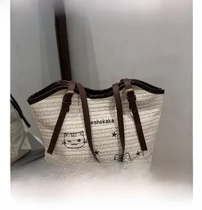 Detailed view of cream woven tote bag featuring cute cartoon cat embroidery and leather trim