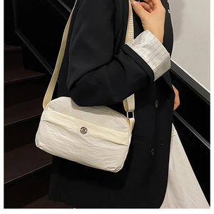 Detail of off-white wrinkled nylon crossbody bag with metal logo and fabric strap
