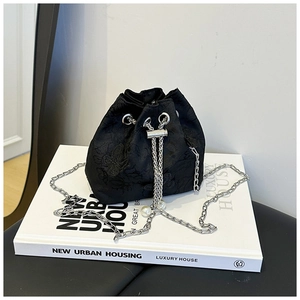 Détail du sac seau noir brodé avec breloques perles sur cordon et chaîne argentée