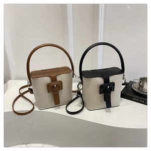 Vue détaillée de deux sacs seaux en toile avec contrastes en cuir noir et marron