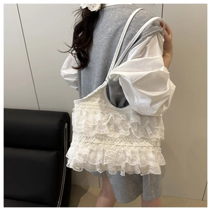 Detail of white lace tote bag featuring multi-layer ruffles and delicate textures