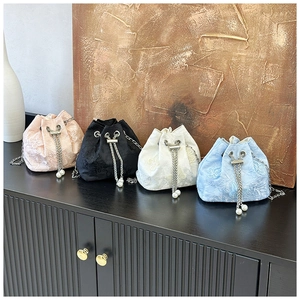 Détail de sacs seaux brodés en jacquard avec cordons perlés et bandoulière chaîne
