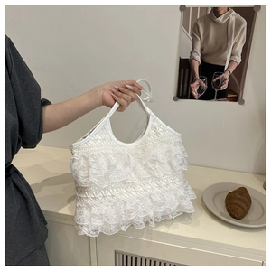 Detailed view of layered lace ruffles and embroidery on white summer beach tote bag