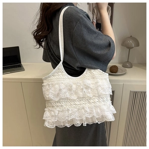 Close-up of white lace shoulder bag featuring layered ruffles and delicate embroidery