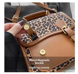 Detail showing the vintage metal magnetic buckle on leopard print and brown leather bag