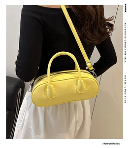 Detail of lemon yellow Boston handbag showing the matte leather texture and shoulder strap