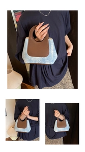 Close-up of denim bucket bag showing brown round cutout handle and leather stitching detail