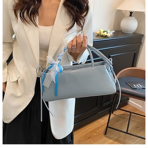 Détail du sac bleu clair avec nœud en dentelle blanche et ruban sur la poignée