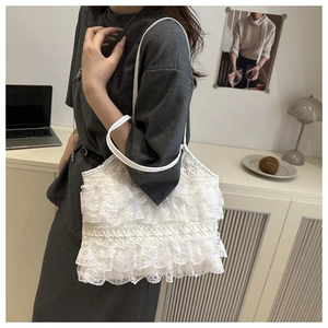 Detail of multi-layer white lace ruffles and delicate fabric on the tote shoulder bag