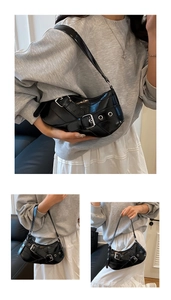 Detail of black patent leather hobo bag featuring large silver metal buckle and grommet