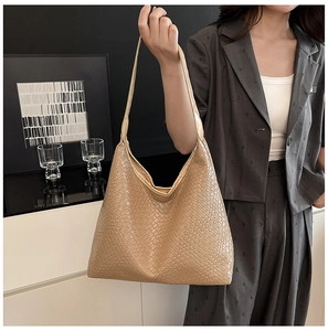 Detailed close-up of beige woven texture and Hobo design on a large capacity shoulder bag