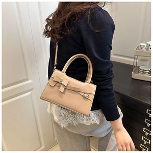 Détails d'un élégant sac à main beige avec nœud papillon et bandoulière réglable
