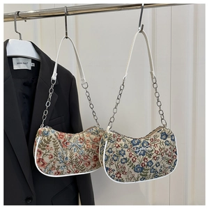 Detailed view of floral jacquard hobo bags with silver bow accents and chain straps