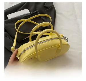 Detail shot of bright yellow bowling bag showing smooth PU leather texture and silver zipper