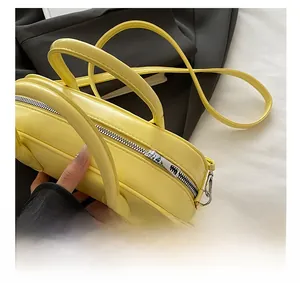 Detail of a bright yellow PU Boston bag showing the smooth metal zipper and leather texture