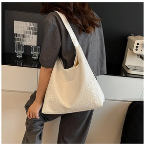 Detail of woven white leather tote bag texture and large interior space on shoulder