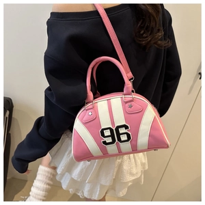 Détail du sac bowling rose et blanc Y2K avec écusson numéro 96 et clous en étoile