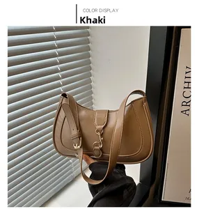 Macro shot of khaki leather shoulder bag with metallic buckle and adjustable strap