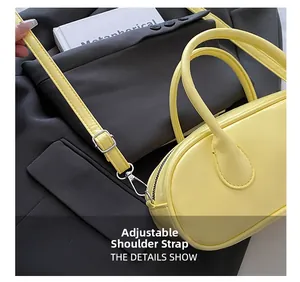 Detail view of adjustable and detachable yellow PU shoulder strap buckle on handbag