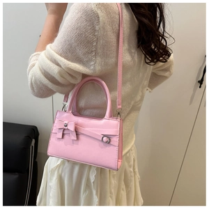 Détail du sac à main rose montrant le nœud décoratif et la bandoulière ajustable