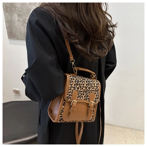 Rear view of a chic leopard print and brown leather mini backpack on a female model