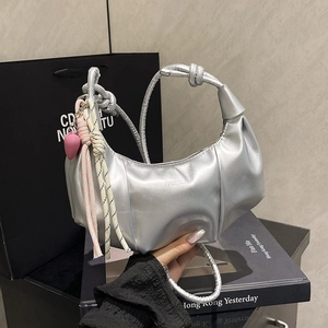 Silberne Hobo-Tasche in Faltenoptik mit Knotengriff und pinkem Herzanhänger