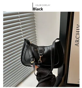 Close-up of sleek black patent leather shoulder bag with elegant gold metal buckle detail
