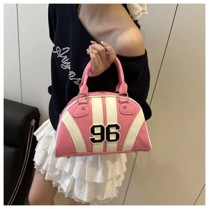 Detalle del bolso bowling rosa y blanco con parche número 96 y remaches estrella estilo sport
