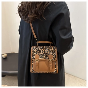 Detail of leopard print stitching handbag with vintage buckles and brown leather base