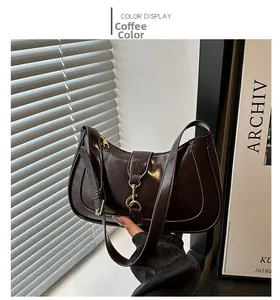 Detail view of dark brown faux leather hobo bag featuring a golden piston clasp and glossy finish