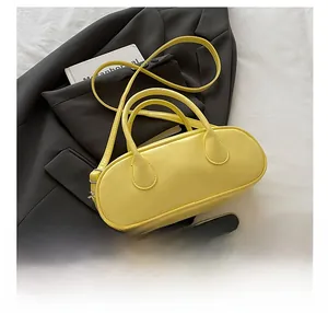 Size comparison of yellow mini baguette bag with smartphone and adjustable strap